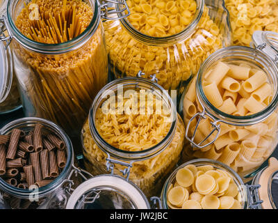 Photo de différents types de pâtes dans de grands pots de verre. Banque D'Images