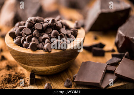 Bol de chocolat et diverses pièces en chocolat sur une planche à découper Banque D'Images