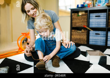 Mère Fils d'apprentissage (4-5) pour attacher les chaussures Banque D'Images