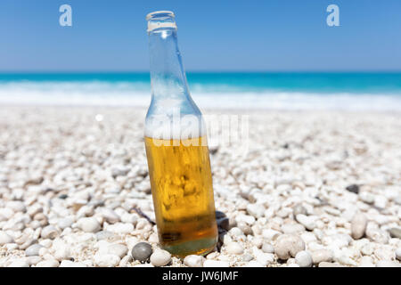Avec la bouteille de bière light sur la plage par la mer Banque D'Images