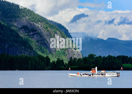 Lindesnes, Norvège - 1 août 2017 : Documentaire de voyage des touristes équitation le bateau à vapeur musée Bjoren sur lac de montagne. Paysage sombre avec la montagne Banque D'Images