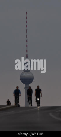 Les cyclistes équitation en début de soirée le long de la Frankfurter Alle vers le bord de Berlin, Allemagne, 10 août 2017. La tour de télévision peut être vu dans l'arrière-plan. Photo : Paul Zinken/dpa Banque D'Images