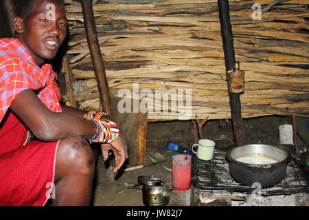 Le Masai Mara / Kenya - Octobre 2013 : l'homme Masai de préparer des aliments à l'intérieur de sa hutte à Boma Masai, situé au sud du Kenya Banque D'Images