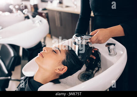 De gros plan femme coiffure cheveux rinçage d'un client . Woman getting hair spa au salon de coiffure. Banque D'Images