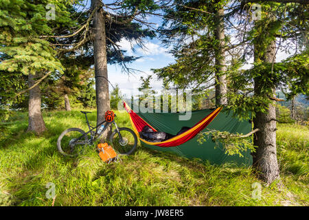 Camping dans les bois avec hamac et sac de couchage sur le vélo de montagne voyage aventure dans les montagnes vertes. Camping voyage vtt vélo avec sac à dos quand. L Banque D'Images