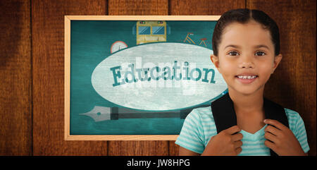 Portrait of smiling girl avec sac contre l'éducation contre green chalkboard Banque D'Images