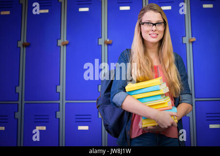 Pretty student dans la bibliothèque à l'école dans des casiers violet fermé Banque D'Images