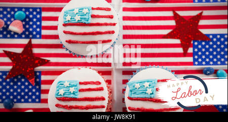 Digital composite image texte de la fête du travail avec contour bleu contre cupcakes on american flags Banque D'Images