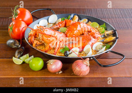 La paella de Valence de fruits de mer gastronomique avec des langoustines, des palourdes, moules et calamars sur salé riz safrané avec les pois et les tranches de citron, vue en gros Banque D'Images