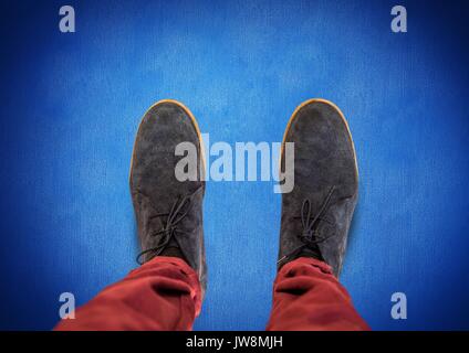 Digital composite de chaussures gris sur fond bleu avec pieds Banque D'Images
