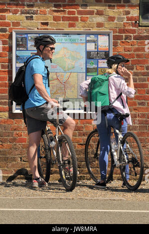 Une dame et un homme femme demandant à orientation pour les cyclistes du vélo comme sur l'île de Wight, à Newport de parler à un homme avec un chien regardant une carte Banque D'Images