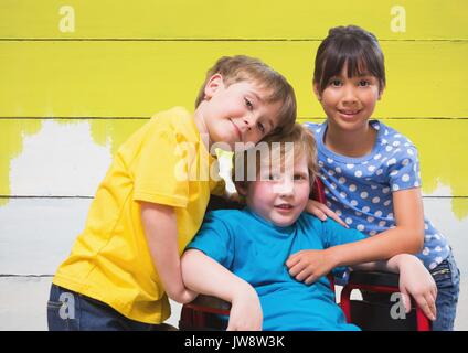 Composite numérique des personnes handicapées en fauteuil roulant avec des amis garçon avec fond de bois peint en jaune vif Banque D'Images