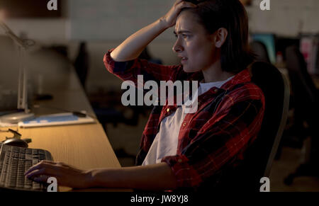 À l'aide de pc de bureau exécutif frustrés at desk in office Banque D'Images