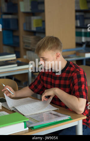 High angle view of young male student studying in classroom Banque D'Images
