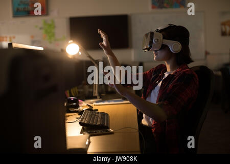 Executive en utilisant casque de réalité virtuelle alors que working at desk in office Banque D'Images