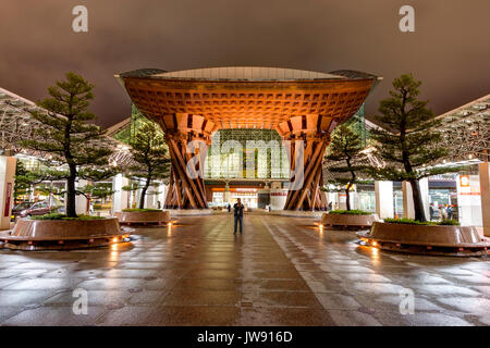 Vue de la porte tambour Tsuzumi, aka gate, à la gare de Kanazawa, Japon. La nuit après la pluie. Vue par la porte en verre de Motenashi dome. Peu de gens Banque D'Images