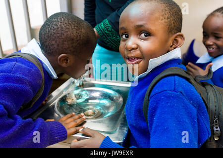 Les jeunes enfants de l'école de fontaine à eau potable de Kibera à Kibera, Nairobi, Kenya Banque D'Images