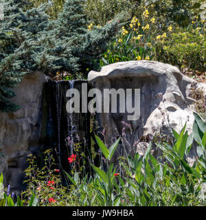 Une petite cascade artificielle entre les grosses pierres Banque D'Images