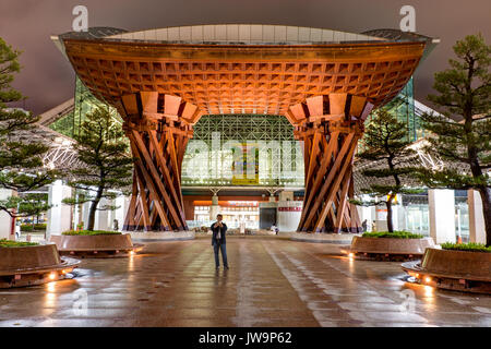 Vue de la porte tambour Tsuzumi, aka gate, à la gare de Kanazawa, Japon. La nuit après la pluie. Vue par la porte en verre de Motenashi dome. Peu de gens Banque D'Images