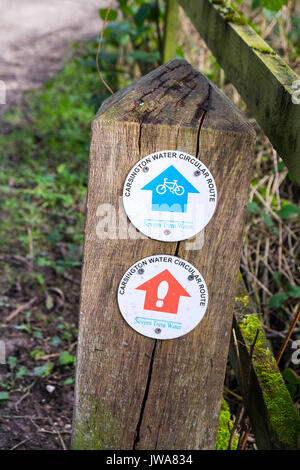 Un panneau en bois avec des flèches pour le vélo et la marche à pied circulaire à l'eau ou un réservoir Carsington, Carsington, Derbyshire, Angleterre, RU Banque D'Images