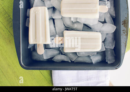 Glace vanille sucettes glacées de la fonte, dans le bac de glace sur journée d'été. Vue de haut en bas. Banque D'Images
