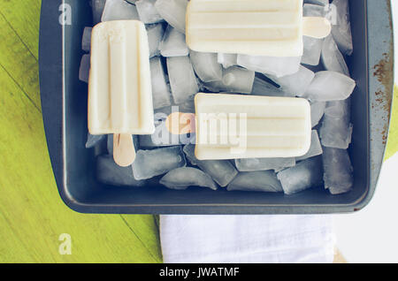 Glace vanille sucettes glacées de la fonte, dans le bac de glace sur journée d'été. Vue de haut en bas. Banque D'Images