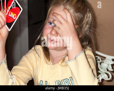 Jeune fille 6-7 ans à la cartes à jouer jeu de carte UNO. Myrleen Pearson Banque D'Images