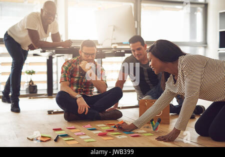 Le joyeux groupe moderne d'employés de bureau assis et la planification, alors que la réunion. Banque D'Images