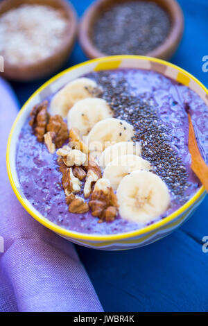 Bol à smoothie aux bleuets, les écrous , les bananes et les graines de chia, petit déjeuner végétalien sain Banque D'Images