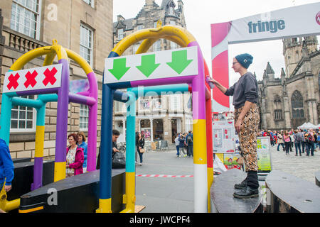 Artiste Ellie Mills de l'art du spectre a été chargé d'essuyer la peinture des barrières anti terreur qui sont en place sur le Royal Mile pour protéger les foules pendant Banque D'Images