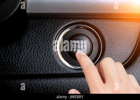 Close up de doigt qui appuie sur le bouton Démarrer/arrêter le moteur d'une voiture. Banque D'Images