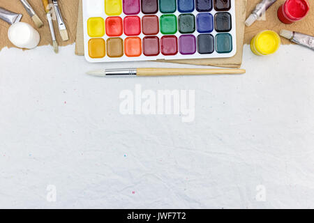 Les peintures à l'aquarelle avec palette de pinceaux sur fond de papier recyclé gris Banque D'Images