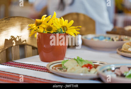 Un pot de marguerites jaunes sur une table de dîner dans le style ukrainien Banque D'Images