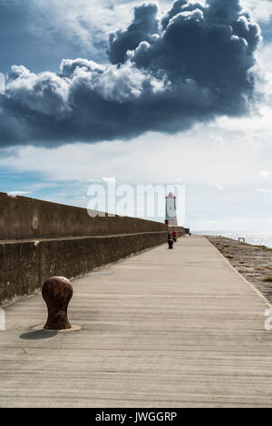 Phare à la fin de la jetée ou digue, Weymouth, Dorset, Angleterre, sous les nuages de tempête Banque D'Images