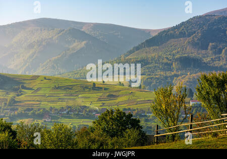 Belle région rurale en campagne montagneuse. clôture sur les champs à flanc de brume du matin, au début de l'automne Banque D'Images