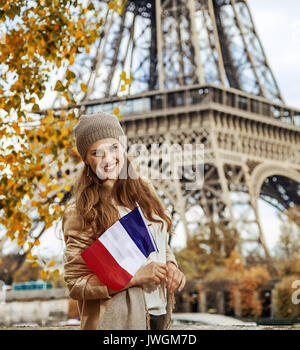 Escapades d'Automne à Paris. souriante jeune femme élégante sur le quai à Paris, France avec le drapeau Banque D'Images