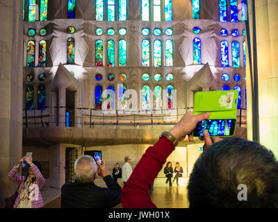 Les touristes prennent des photos avec leur téléphone intelligent à l'intérieur de la Sagrada Familia, la cathédrale de Barcelone qui est encombrée de visiteurs de partout dans le monde Banque D'Images