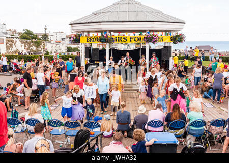 Folk Festival annuel de Broadstairs Semaine. Les danseurs folkloriques, St Clements côté Morris danse avec les membres de l'auditoire de la partie, sur des planchers en face d'audience avec kiosque à musique derrière eux avec des musiciens à jouer. Banque D'Images