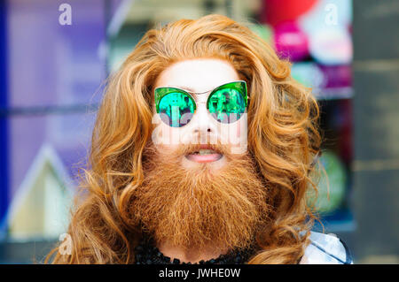 Edinburgh, Ecosse, Royaume-Uni. 12 août, 2017. 7ft de haut Gingzilla avec du gingembre artiste faites glisser les cheveux et barbe et portant des lunettes de soleil miroir vert effectue dans les rues de la ville à la fin de la première semaine de la 70e anniversaire de l'Edinburgh International Fringe Festival. Credit : Skully/Alamy Live News Banque D'Images