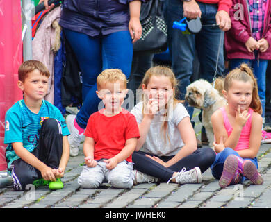 Edinburgh, Ecosse, Royaume-Uni. 12 août, 2017. Une rangée de quatre enfants à regarder les artistes interprètes ou exécutants sur les rues pavées de la ville à la fin de la première semaine de la 70e anniversaire de l'Edinburgh International Fringe Festival. Credit : Skully/Alamy Live News Banque D'Images