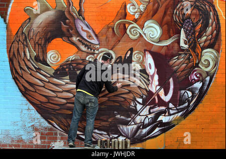 Würzburg, Allemagne. 12Th Aug 2017. Un artiste de graffiti peintures par pulvérisation le mur d'un ancien supermarché dans l'ancienne base militaire américaine à Würzburg, Allemagne, 12 août 2017. Les artistes de rue du monde entier sont réunis à la ville bavaroise de l'Streetmeet Festival, une semaine de festival de graffiti. Photo : Karl-Josef Opim/dpa/Alamy Live News Banque D'Images