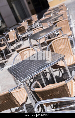 Des tables et des chaises de métal sur la terrasse d'un bar Banque D'Images