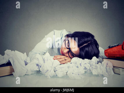 Jeune femme dormir à son bureau désorganisé Banque D'Images