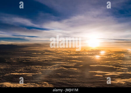 Vue aérienne du vol d'un avion au-dessus des nuages , Crépuscule du temps avec coucher du soleil flare Banque D'Images