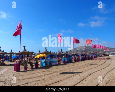 AGADIR, Maroc sur l'Europe Février 2017 : des drapeaux rouges sur la plage dans la ville de voyage avec ciel bleu ensoleillé chaud en journée d'hiver. Banque D'Images