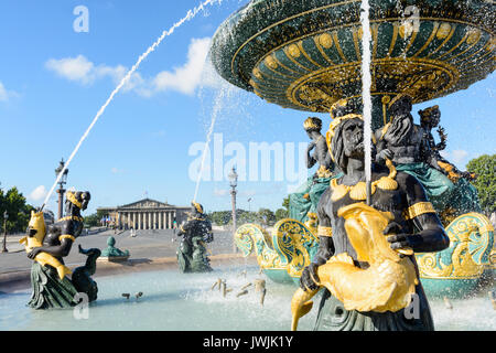 La fontaine des mers sur la place de la Concorde à Paris avec les Nereids et les Tritons qui tiennent des poissons dorés, et le Palais Bourbon au loin. Banque D'Images