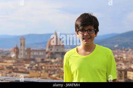 Smiling boy with long hair et l'arrière-plan de la ville de Florence en Italie Banque D'Images