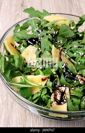 Salade de roquette (fusée) habillé avec sauce de soja balsamique , copeaux de parmesan et de poivre noir fraîchement moulu, de sésame. Banque D'Images