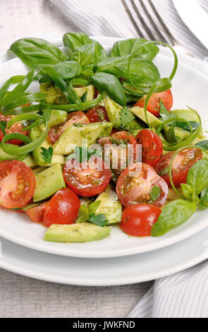 Tranches d'avocat délicates avec tomates, habillé de sauce pesto. Banque D'Images