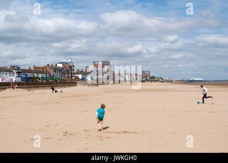 Famille jouant au football sur la plage, Tide Out, English Coastal Resort, Summertime, Seaside Town, Cleethorpes, sable, sortie en famille, jetée de Seaside Banque D'Images